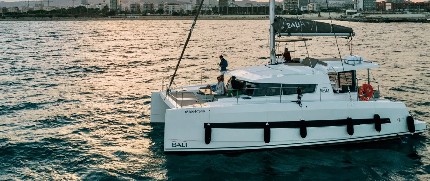 Boat tour on a catamaran at sunset in Barcelona with wine, coastal views, and local stories. 