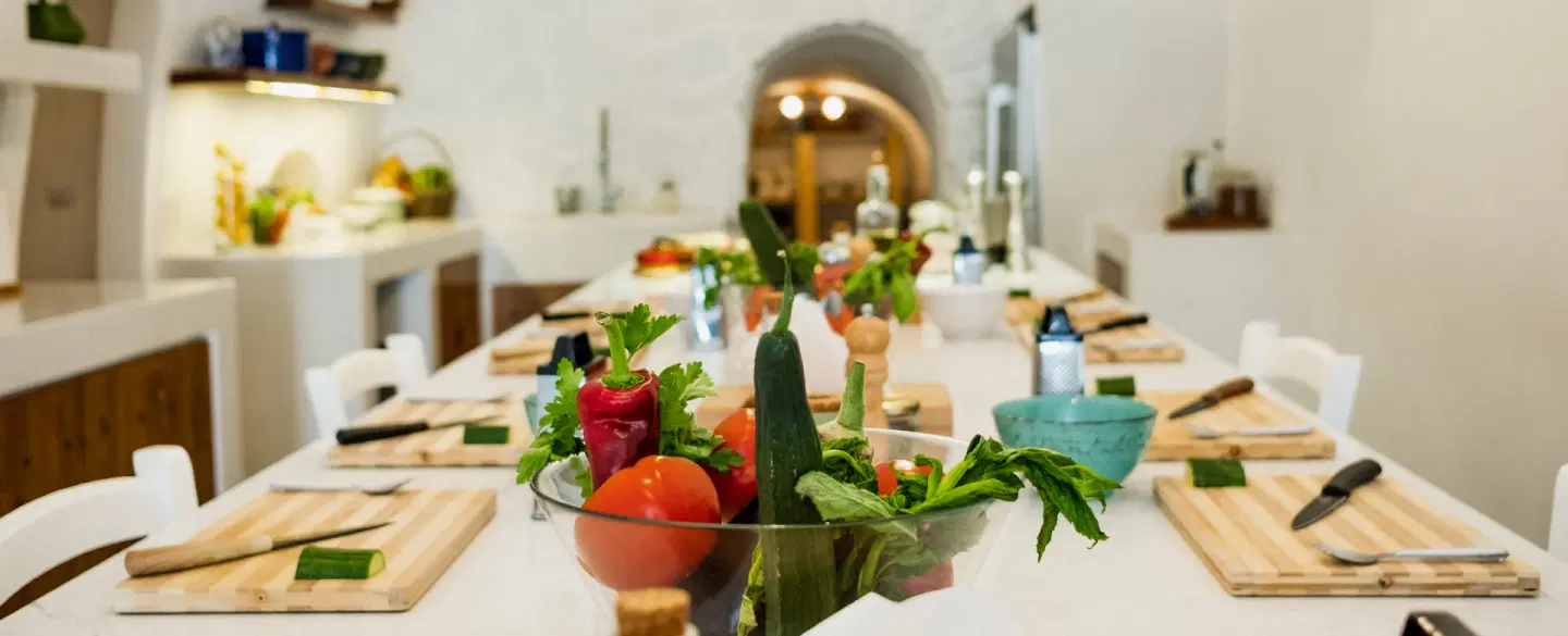 Cooking Class set in a cave kitchen in Santorini, preparing Greek dishes and dining together.
