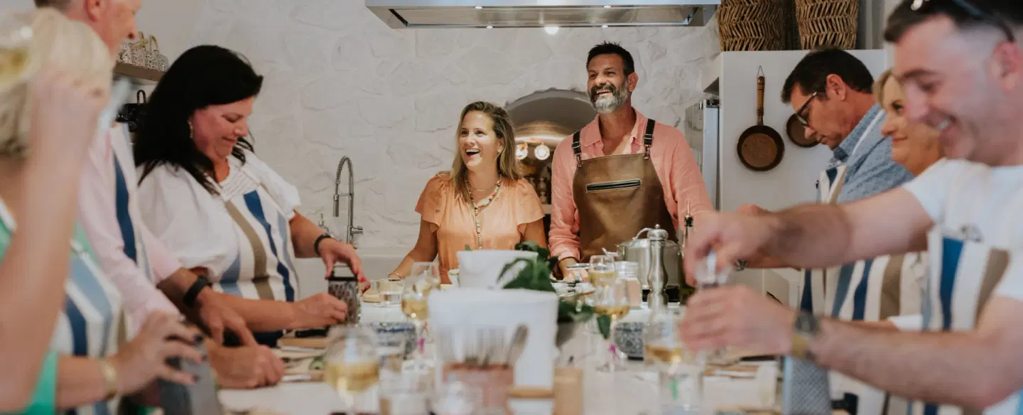 Cooking Class set in a cave kitchen in Santorini, preparing Greek dishes and dining together.