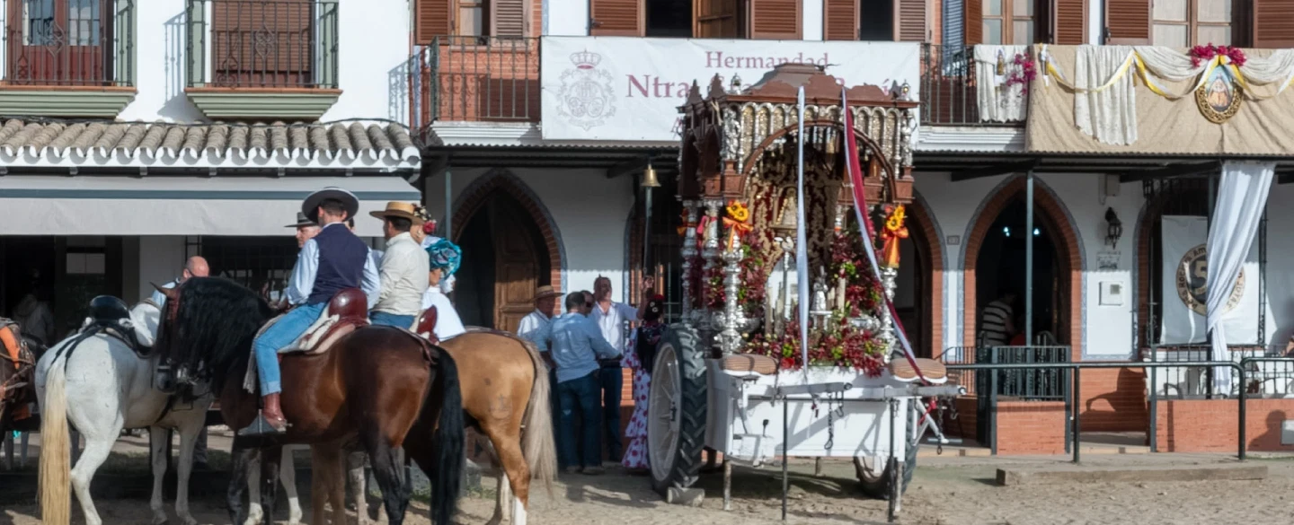 A day inside El Rocío when the village is alive with festival — homes, meals, brotherhoods, song.