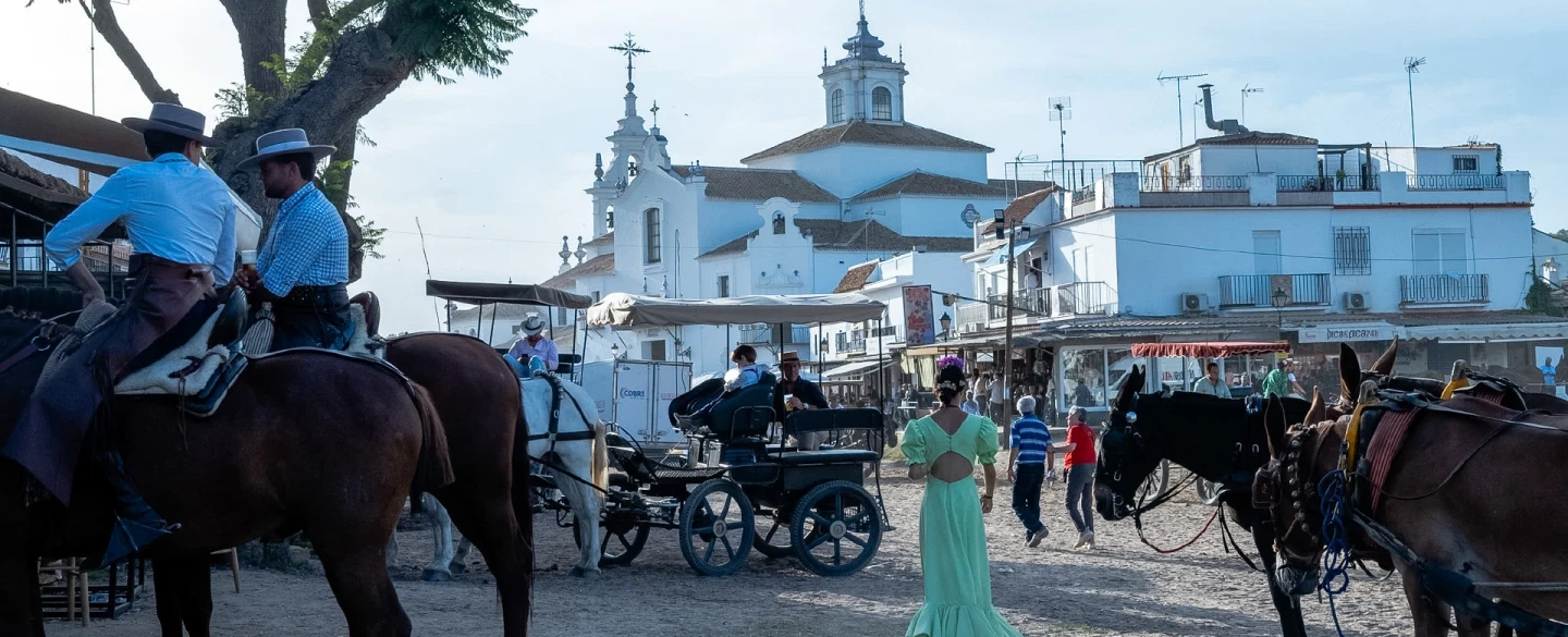 A day inside El Rocío when the village is alive with festival — homes, meals, brotherhoods, song.