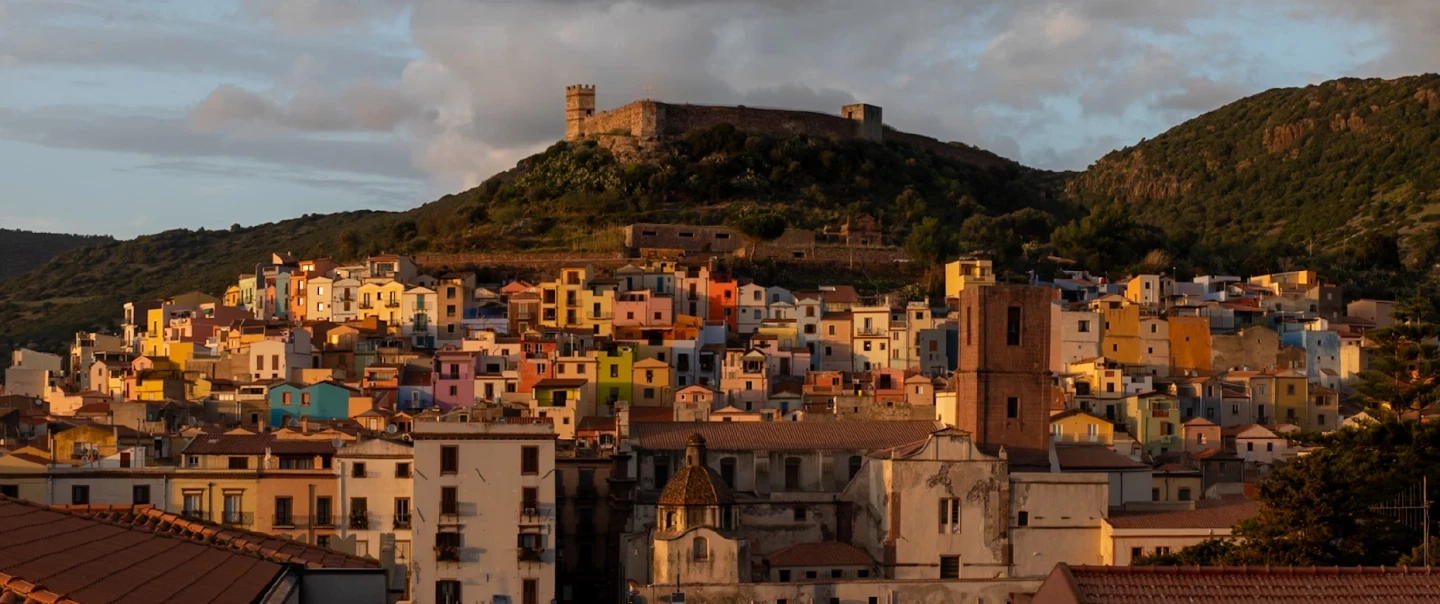 Photo Walk to explore a village near Alghero, in Sardinia, and capture its colored houses at sunset.